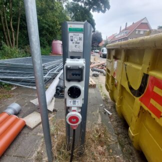 Construction site on road. The available public charge point is used to power tools, equipment and pumps